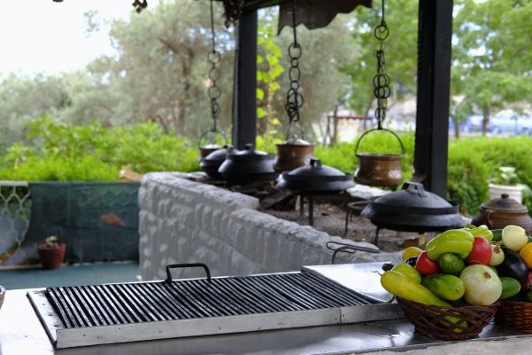 An outdoor kitchen with barbecue and a fruit bowl